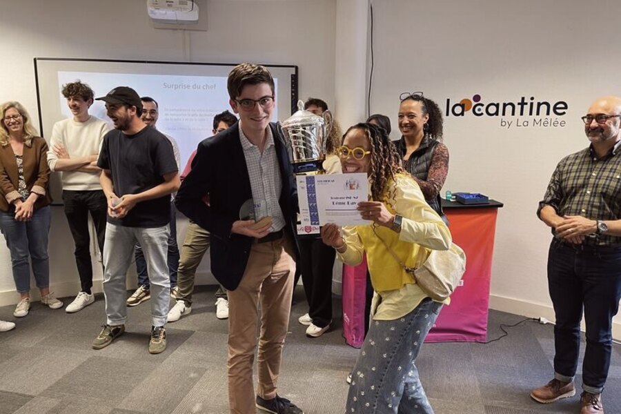 Remise de prix en intérieur, plusieurs personnes tenant trophées et diplôme.
